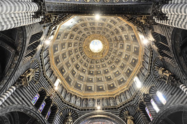 The dome of the cathedral with starry sky and black and white striped marble columns and round arches, Siena, Tuscany, Italy, Europe