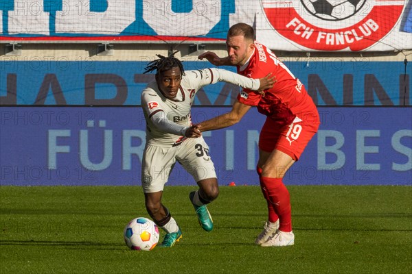 Football match, Jeremine FRIMPONG Bayer Leverkusen left in duel with Jonas FOeHRENBACH 1.FC Heidenheim, Soccer stadium Voith-Arena, Heidenheim