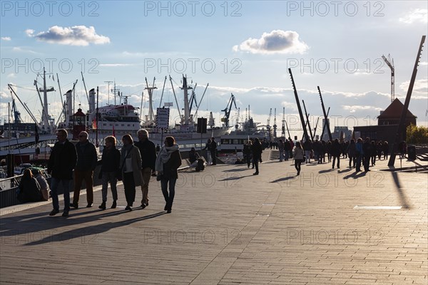 Jan Fedder Promenade, pedestrians on the waterfront promenade at the harbour, Elbe riverbank, backlight, Hamburg, Germany, Europe