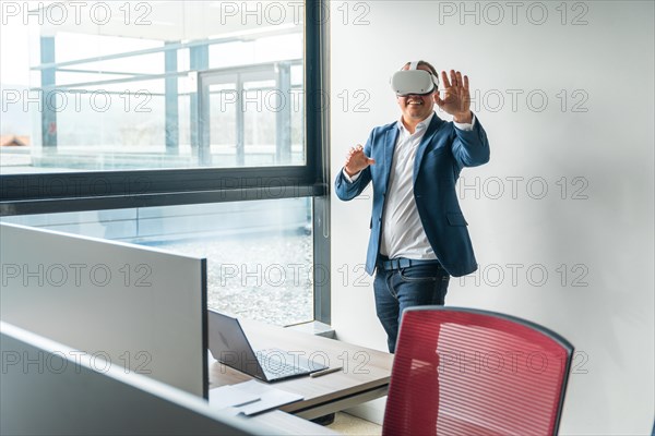 Caucasian mature businessman using mixed reality goggles in the office