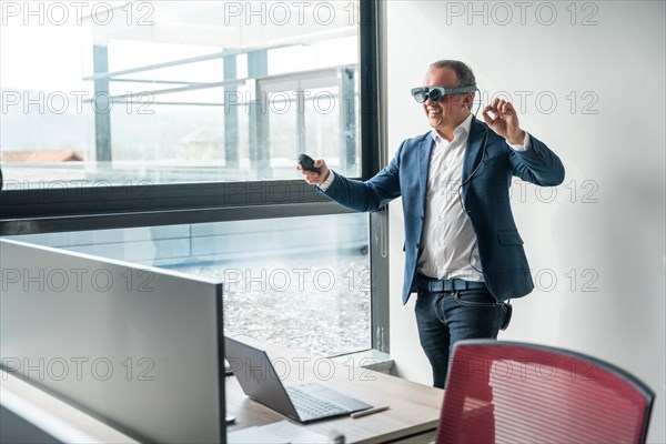 Businessman having fun testing new mixed reality goggles in the office