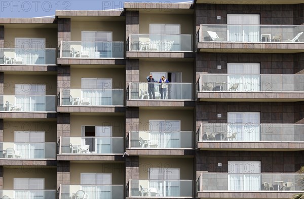 An elderly couple looks out from a balcony of an apartment complex in Torremolinos, Costa del Sol, 13/02/2019