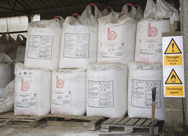 Danger fertiliser store oxidising agent sign Ammonia Nitrate bags in barn, Suffolk, England, United Kingdom, Europe