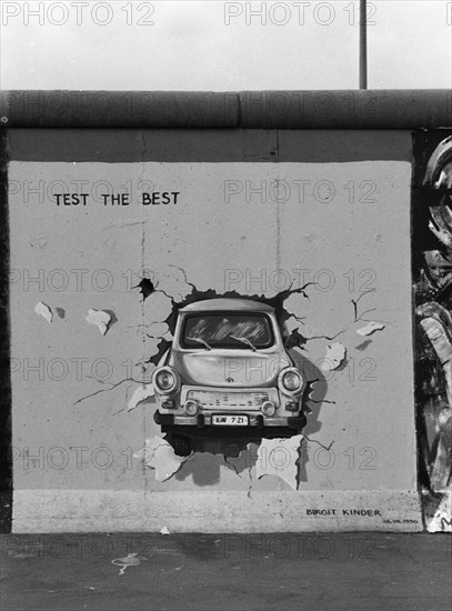 The Birgit-Kinder painting of the East Side Gallery with a GDR Trabant car and the inscription TEST THE BEST, summer 1990, Muehlenstrasse, Friedrichshain, Berlin, Germany, Europe