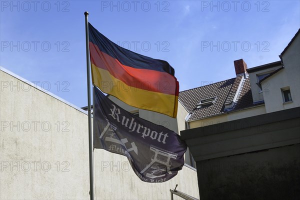 A German flag and a flag with the inscription Ruhrpott hanging on the flagpole of a house, Herne, 26 July 2019