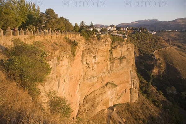 Historic buildings perched on sheer cliff top in Ronda, Spain, Europe