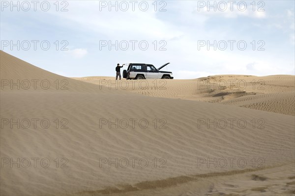 Symbolic image of car breakdown with Nissan Patrol off-road vehicle in the Mesr Desert, Iran. The Mesr Desert is part of the central Dashte-Kavir desert, 12.03.2019