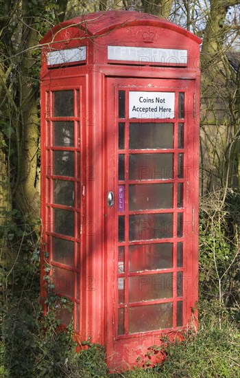 'Coins Not Accepted Here' sign on rural red telephone box, Suffolk, England, United Kingdom, Europe