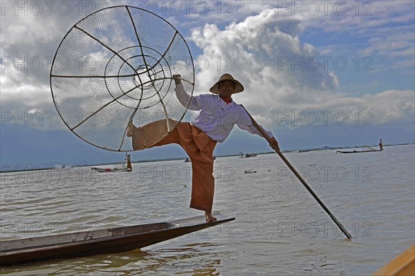 Intha fisherman, local man fishing with traditional conical fishing net, Inle Lake, Burma, Myanmar, Asia