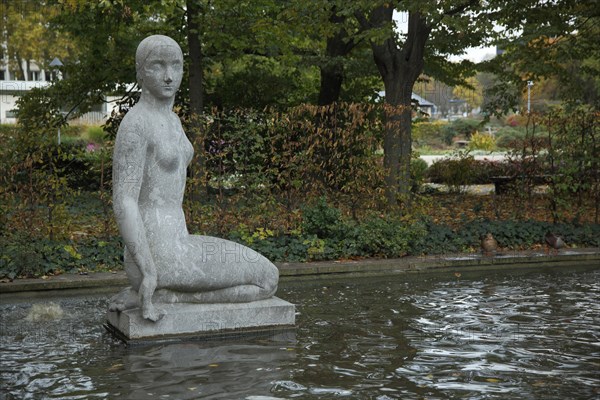 Spring nymph by Arnold Hensler 1912 at the water basin, kneeling, nymph, grey, stone, Reisingeranlage, Wiesbaden, Taunus, Hesse, Germany, Europe