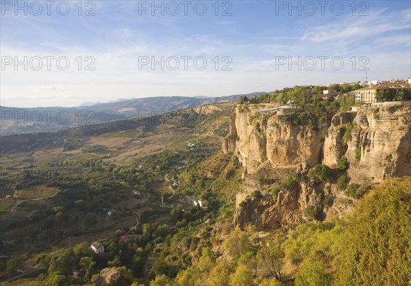 Historic buildings perched on sheer cliff top in Ronda, Spain, Europe