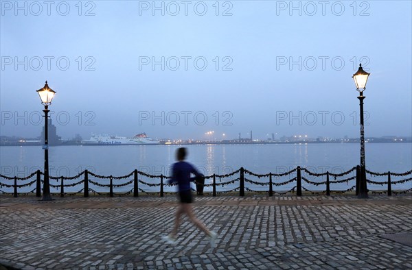 A woman jogs in the morning near the Royal Albert Dock in Liverpool, 01/03/2019