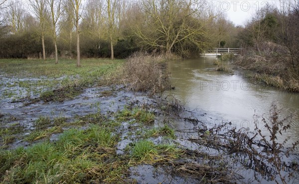 River Deben bursting its banks and flowing overland over levee onto flood plain, near Whitebridge weir, Campse Ashe, Suffolk, England late December 2012