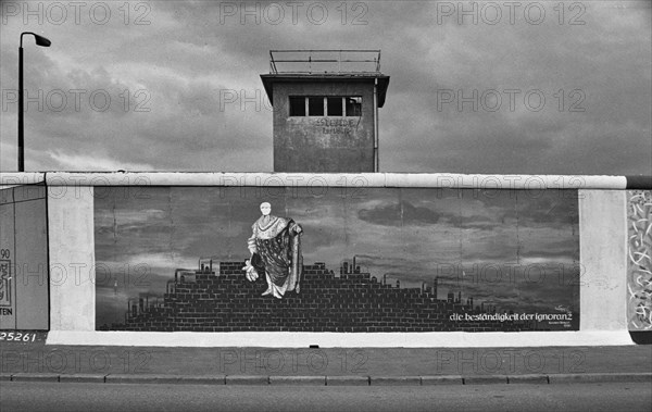 Painting Die Bestaendigkeit der Ignoranz by Karsten Wenzel, behind it a former watchtower of the GDR border troops, summer 1990, East Side Gallery, Muehlenstrasse, Friedrichshain district, Berlin, Germany, Europe