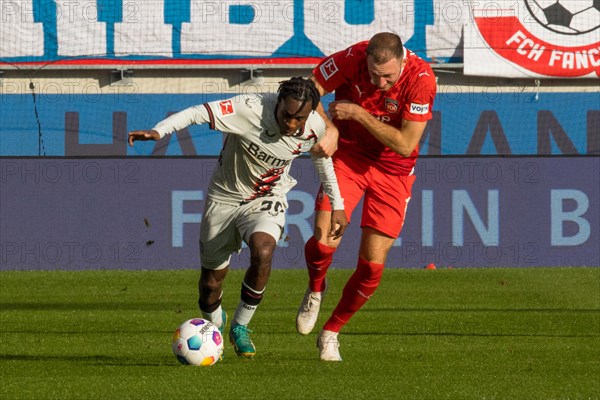 Football match, Jeremine FRIMPONG Bayer Leverkusen left in duel with Jonas FOeHRENBACH 1.FC Heidenheim, Soccer stadium Voith-Arena, Heidenheim