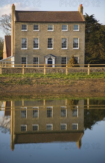High House Farm farmhouse reflected in water of newly dug pond, Bawdsey, Suffolk, England, United Kingdom, Europe
