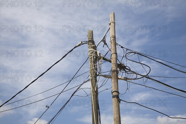 Confused tangle electricity phone line cables telegraph pole blue sky