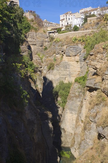 El Tajo canyon of the Rio Guadalevin river with white buildings perched on the cliff top, Ronda, Spain, Europe