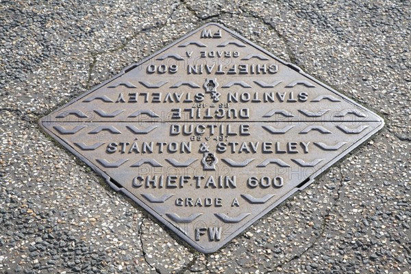 Iron man-hole cover in road UK