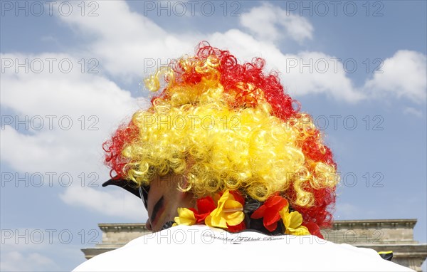 Football fan wears a wig with the colours of the German flag for the World Cup opening match between Germany and Mexico in the fan mile at the Brandenburg Gate in Berlin, 17.06.2018
