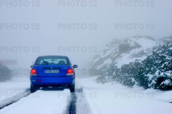 Blue rental car in the snow of the highest mountain Roque de los Muchachos altitude 2400 m, La Palma, Canary Islands, Spain, Europe