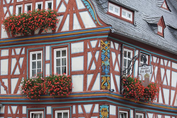 Half-timbered house and Gasthof zur Pfeif with ornaments, floral decoration and nose sign, Koenig-Adolf-Platz, Idstein, Taunus, Hesse, Germany, Europe