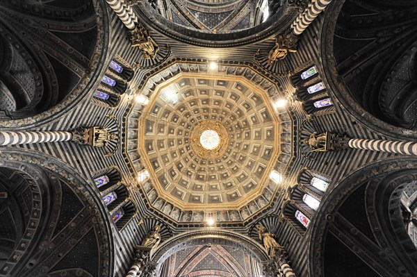 The dome of the cathedral with starry sky and black and white striped marble columns and round arches, Siena, Tuscany, Italy, Europe