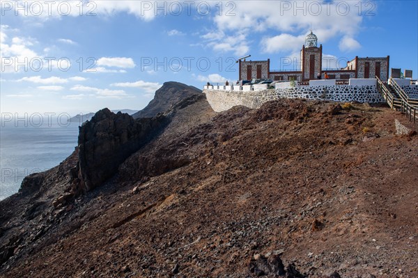 View from viewing platform on cliff of lava rock from prehistoric volcanic eruption and building complex of lighthouse Faro de la Entallada from 50s year 1953 1954 with large glass dome on 183 metres high cliff, behind it Atlantic Ocean, Mirador de Entallada, Las Playitas, Tuineje, Las Palmas, Fuerteventura, Canary Islands, Canary Islands Spain