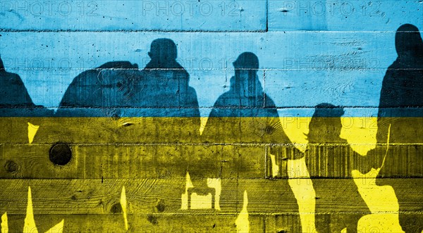 Ukrainian flag painted on a concrete wall with Ukrainian refugees