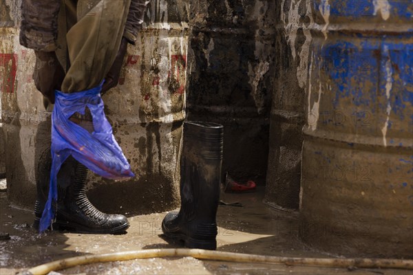 Plastic bag to protect feet on a construction site in Nigeria, 06/02/2024