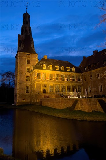 Photo in blue hour with view of castle tower of moated castle Raesfeld in southern Muensterland, in the foreground moat, Freiheit Raesfeld, Raesfeld, North Rhine-Westphalia, Germany, Europe