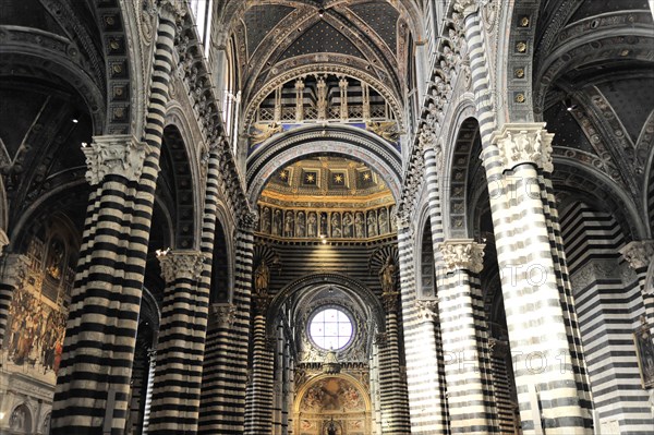 The nave of the cathedral with its black and white striped marble columns, cross and round arches, Siena, Tuscany, Italy, Europe