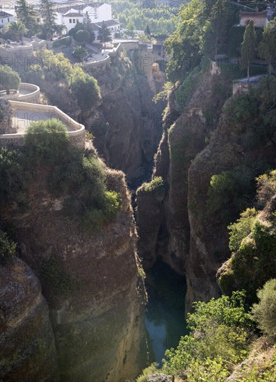 El Tajo canyon of the Rio Guadalevin river with white buildings perched on the cliff top, Ronda, Spain, Europe