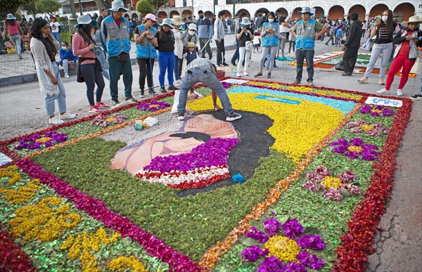 Peruvian man making a floor painting in the Plaza de Armas, spectators watching, Ayacucho, Huamanga province, Peru, South America