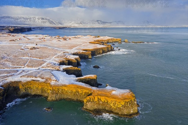 Aerial view over volcanic basalt cliff near Arnarstapi on the southern side of the Snaefellsnes Peninsula in winter, Western Region, Iceland, Europe