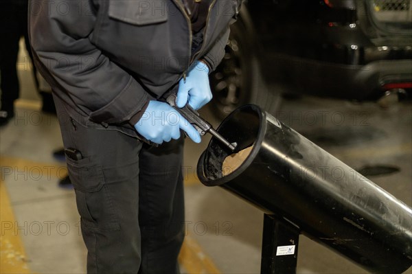 Detroit, Michigan, A police officer checks a handgun turned in at a gun buy-back event to be sure it is unloaded. The event was organized by rapper Skilla Baby and the Brady Center to Prevent Gun Violence. They offered, $100 to $200, depending on the type of weapon