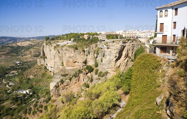 Historic buildings perched on sheer cliff top in Ronda, Spain, Europe