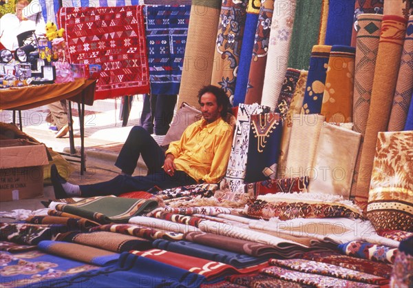 Resting carpet seller at market in Torre del Mar, Andalusia, Spain, Southern Europe. Scanned thumbnail slide, Europe