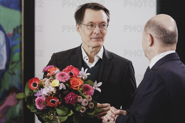 (L-R) Karl Lauterbach (SPD), Federal Minister of Health, and Olaf Scholz (SPD), Federal Chancellor, pictured during the weekly cabinet meeting in Berlin, 21 February 2024. Lauterbach receives the flowers from the Federal Chancellor on his birthday