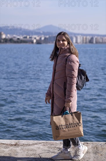 Young woman, coat, shopping bag, shopping, sea, old harbour, Thessaloniki, Macedonia, Greece, Europe