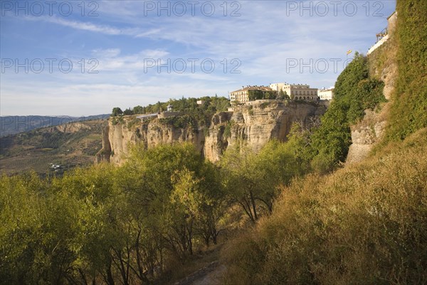 Historic buildings perched on sheer cliff top in Ronda, Spain, Europe