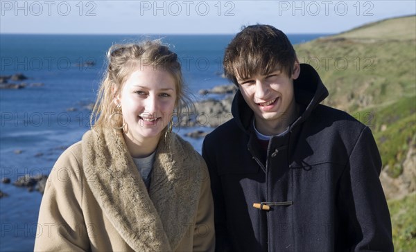 Model released brother and sister twins standing together on sunny winter day, Cornwall, England, UK