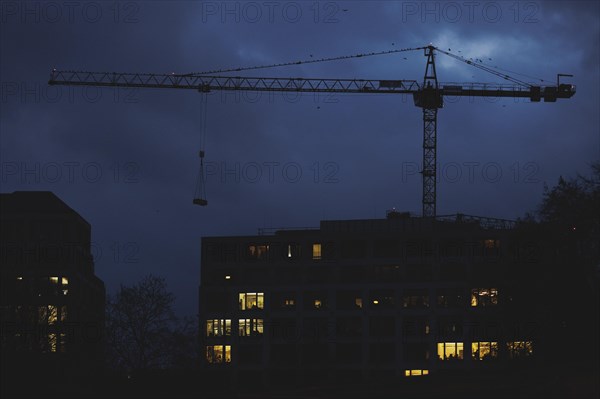 A crane works at blue hour in Berlin, 20/02/2024