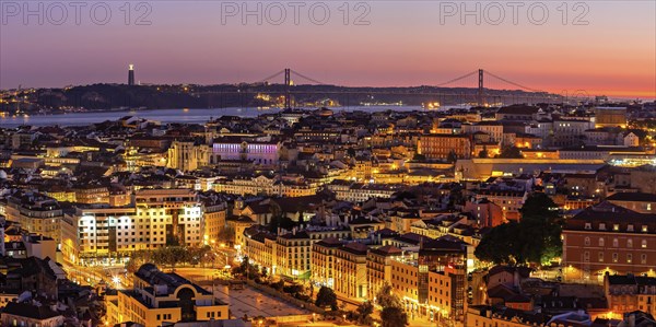 Panoramic picture of the sunset at a viewpoint in Lisbon with a view of the illuminated old town, the bridge and the Tagus River