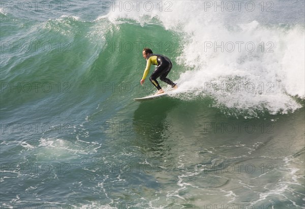 Young man wearing wet-suit surfing in Cornwall, England, United Kingdom, Europe