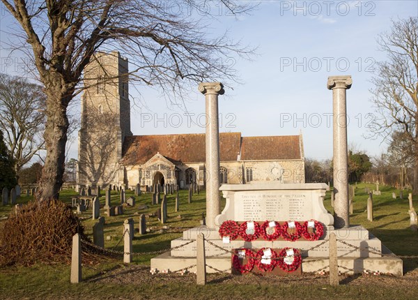 War memorial with poppy wreaths at St John the Baptists church, Snape, Suffolk, England, United Kingdom, Europe