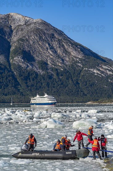 Passengers of the cruise ship Stella Australis land in a rubber dinghy between ice floes on the Pia Glacier, Alberto de Agostini National Park, Avenue of Glaciers, Chilean Arctic, Patagonia, Chile, South America