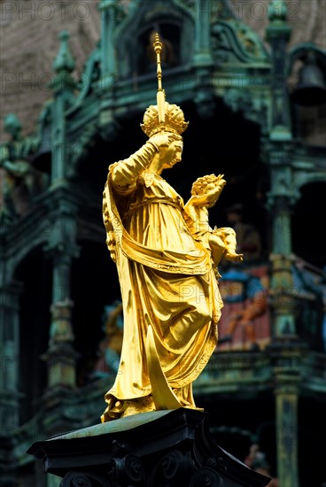 Statue of Maria Mary with Jesus in front of the Glockenspiel of New Town Hall Marienplatz, Munich, Bavaria, Germany, Europe