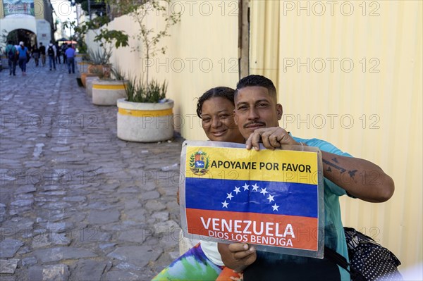 Oaxaca, Mexico, A man and a woman trying to make their way from Venezuela to the United States hold a sign asking for help, Central America