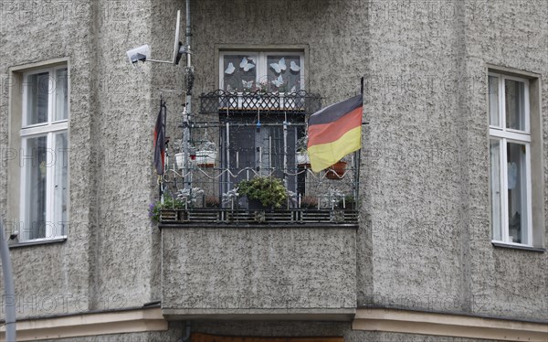 A German flag with a federal eagle flutters on the balcony of a run-down apartment building, Berlin, 22/01/2020